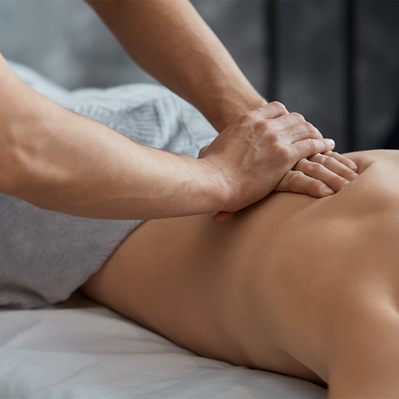 A man lying down receiving a massage from a masseuse.