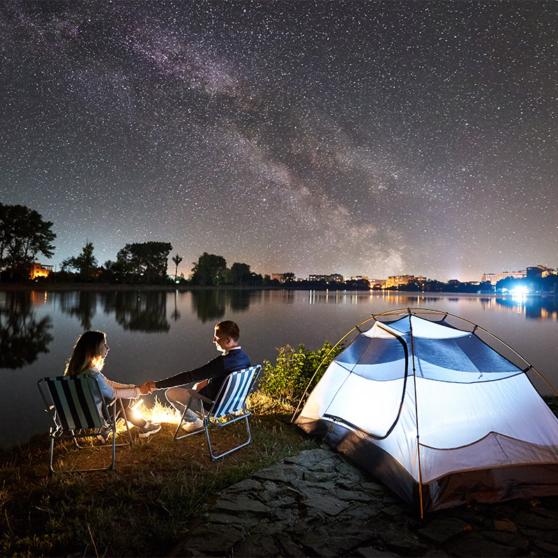 A couple sat on chairs next to their tent, gazing at the stars.