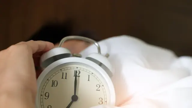 An alarm clock wrapped in silk bedding