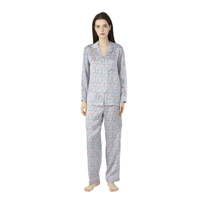 Brunette Lady wearing silk pyjamas in a light blue paisley print